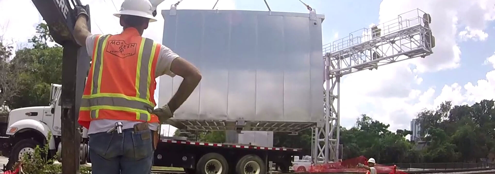 A construction worker unloading steel structure from semitruck.