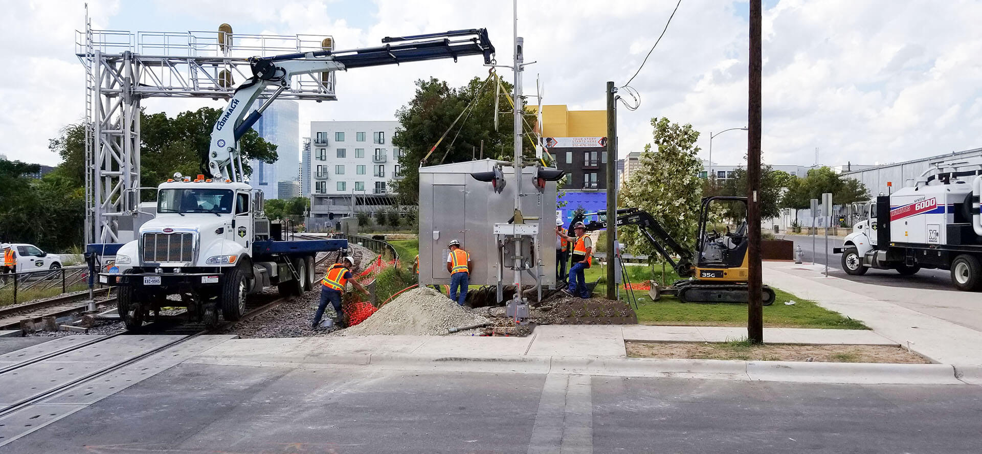 A bright red train travels between tall buildings.