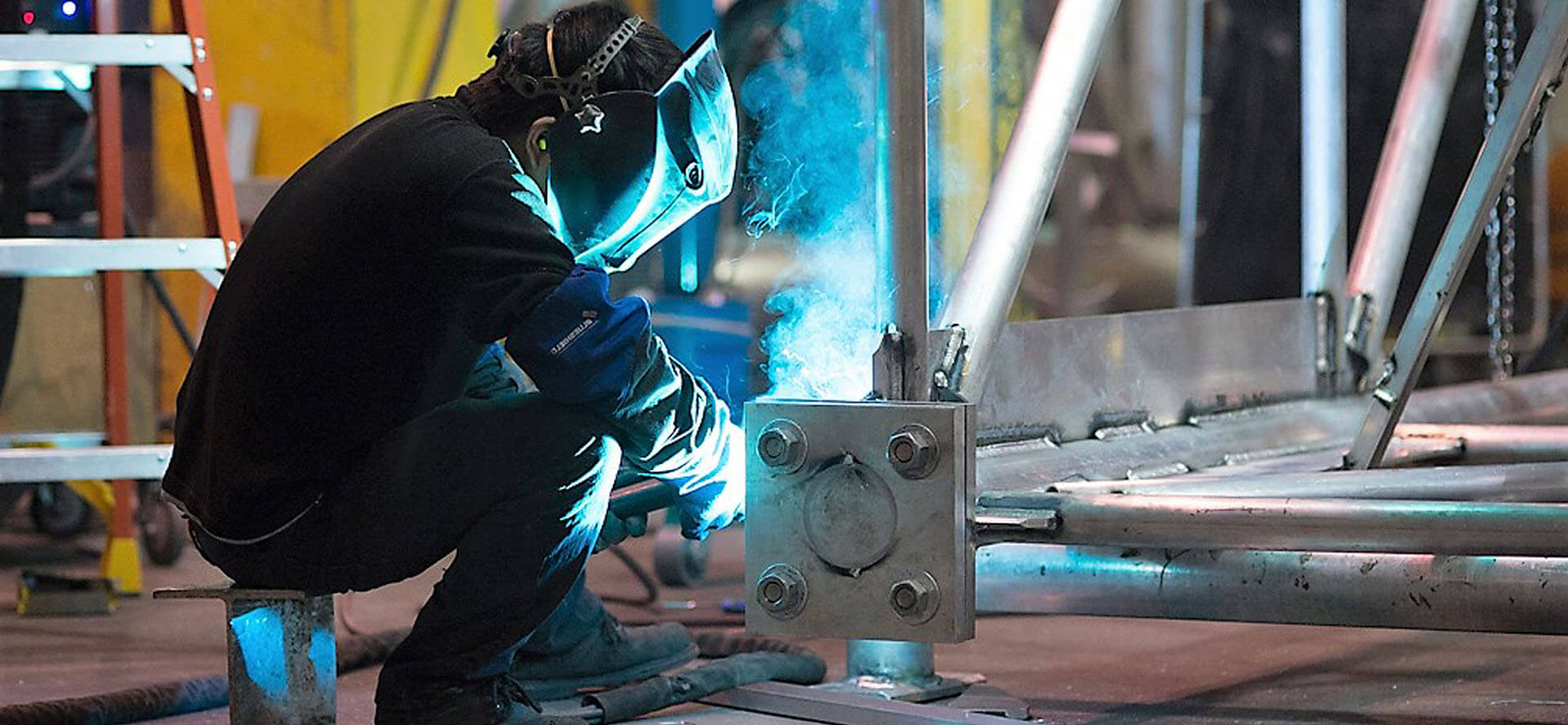 A worker in a safety vest watches a train pass by.